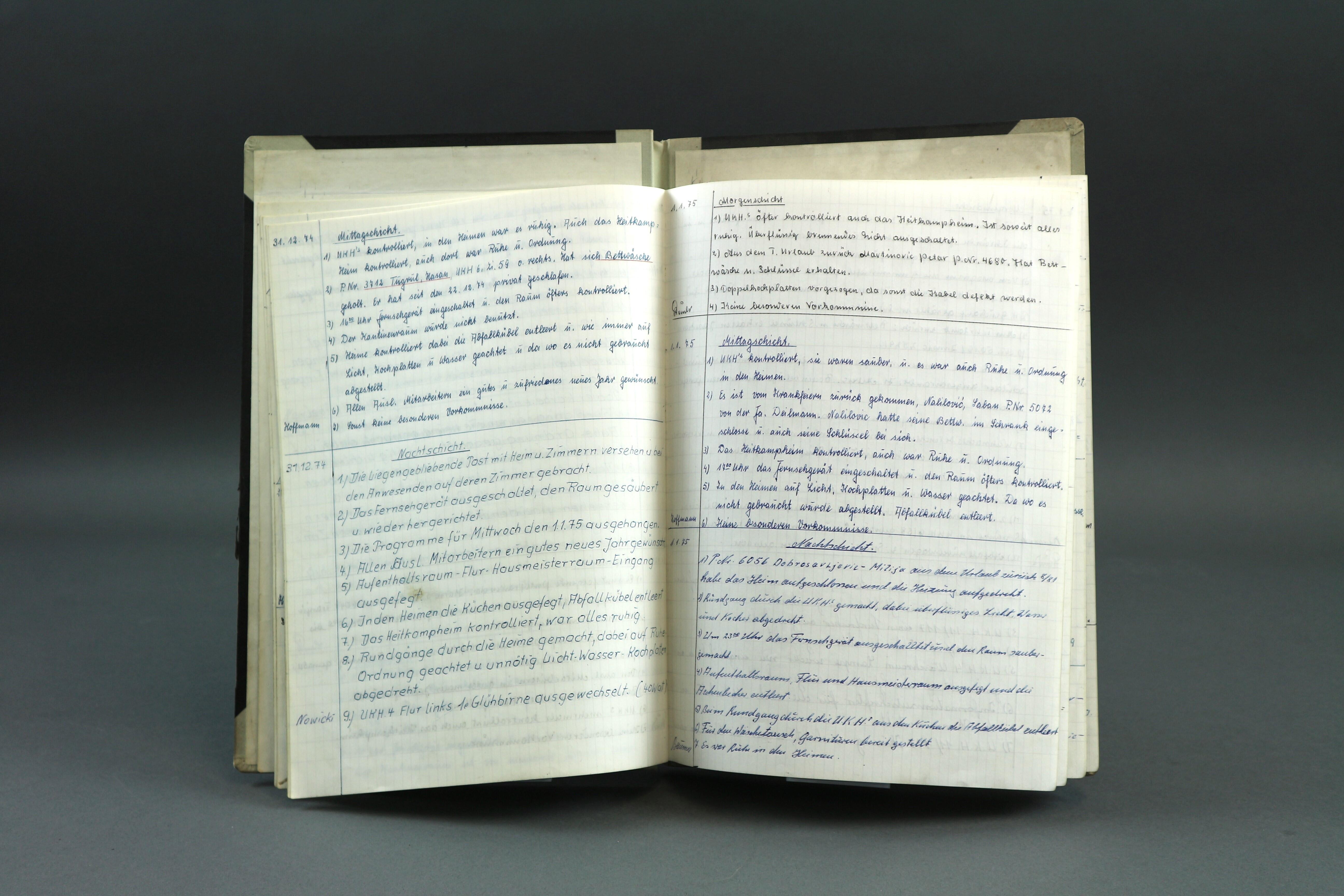 Ein aufgeschlagenes Buch mit handschriftlichen Notizen, in unterschiedlicher Handschrift.
